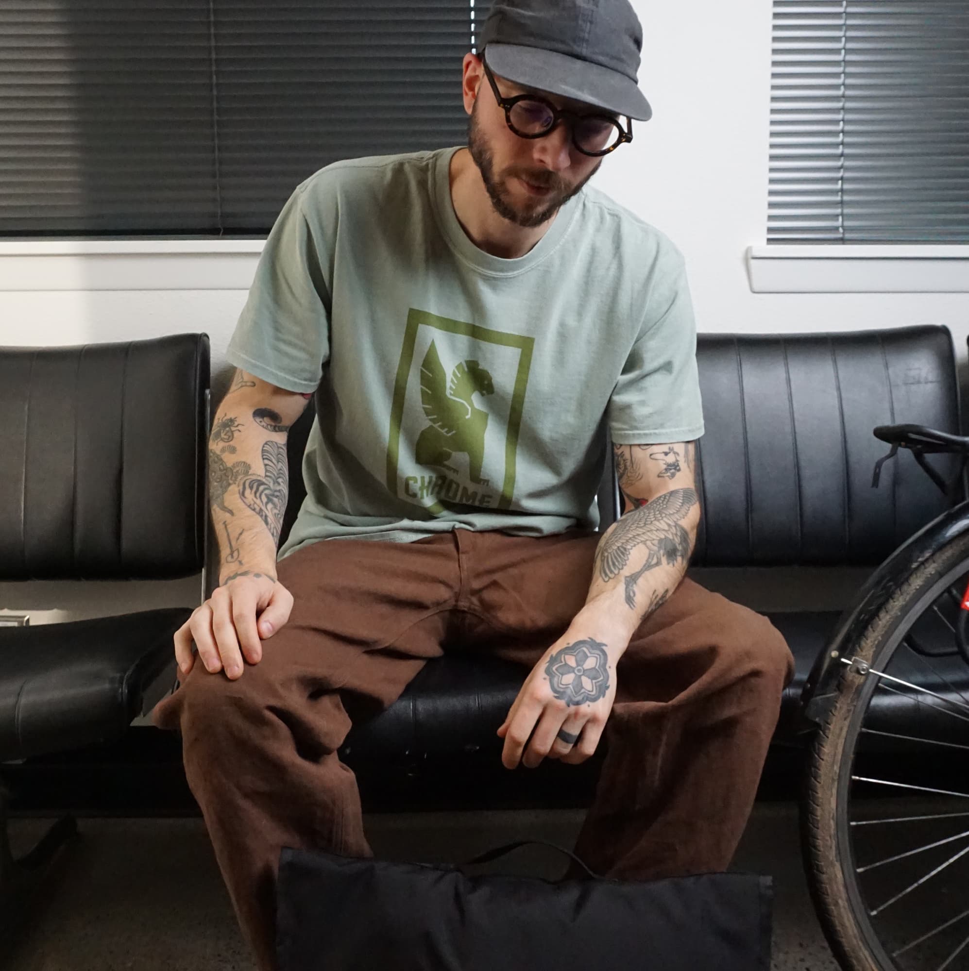 Man wearing a green cotton Short Sleeve T-shirt with a  Chrome logo #color_pebble green
