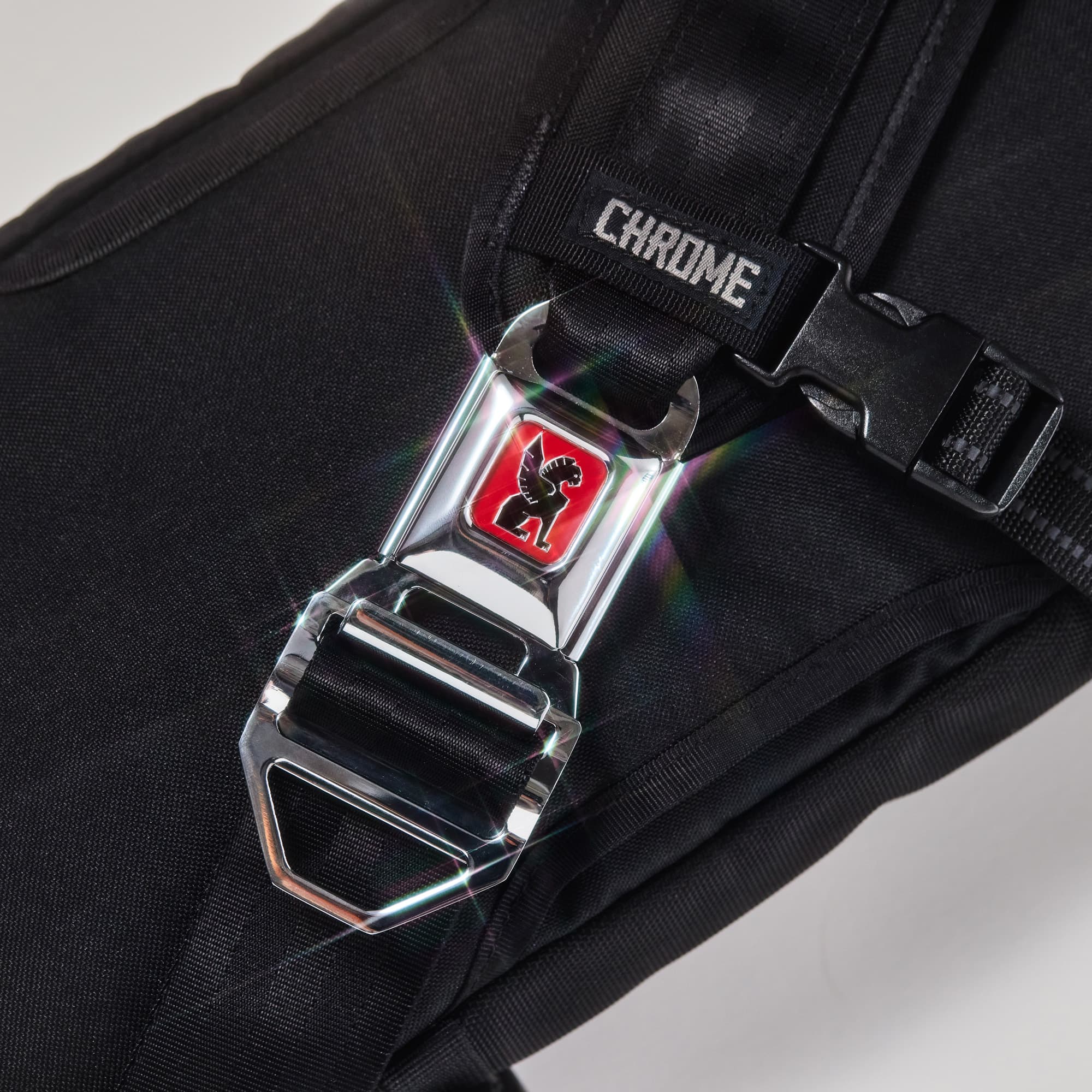 LG iconic seatbelt buckle with Chrome logo on a bag