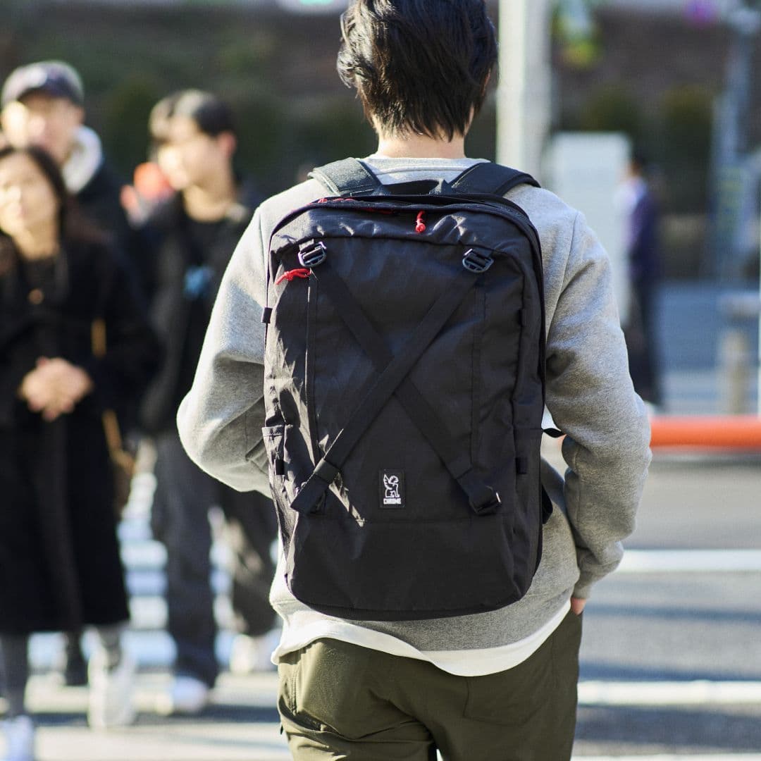 Person wearing a black Cohesive  38l backpack on a Tokyo city street